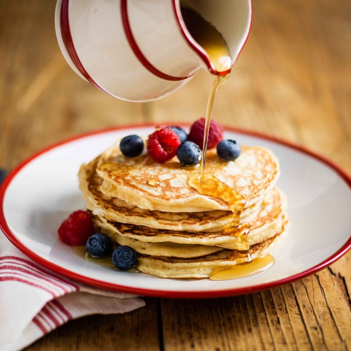 Stack of blueberry pancakes with maple syrup