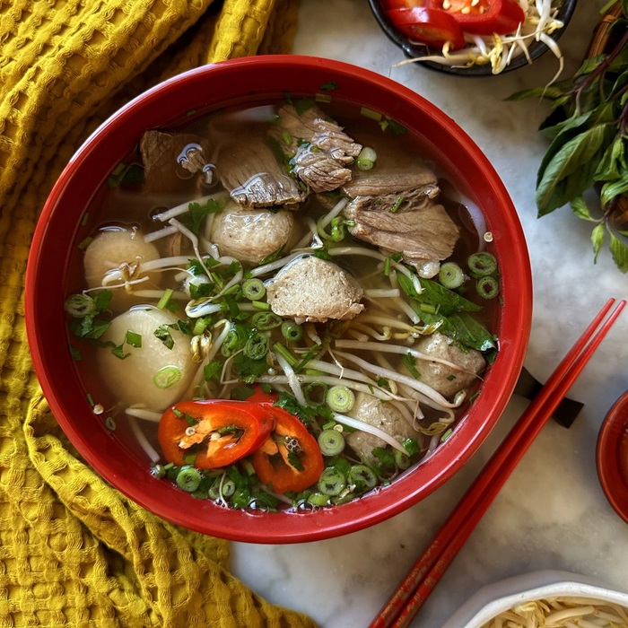 Bowl of pho with herbs and bean sprouts